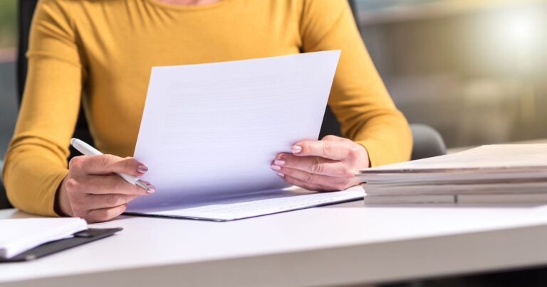 Lady Reviewing and Taking Notes on Document