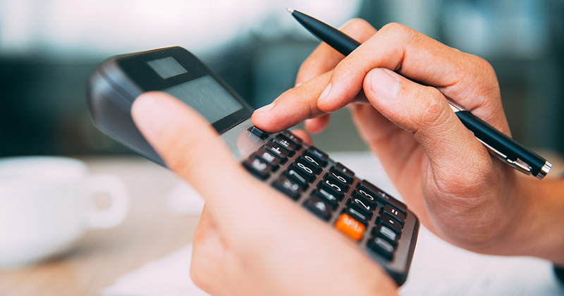 Hands Typing on Calculator