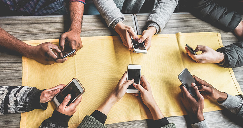 Birdseye View of Six Individuals Scrolling on iPhone