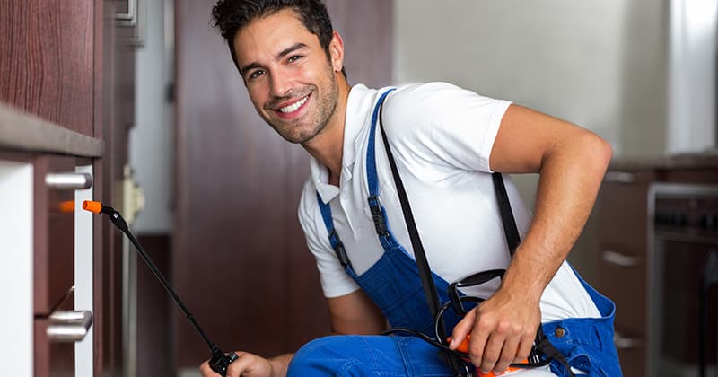 Pest-control-worker-smiling-at-the-camera-and-working