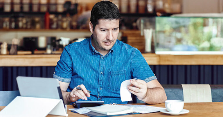 Man-looks-at-business-receipts